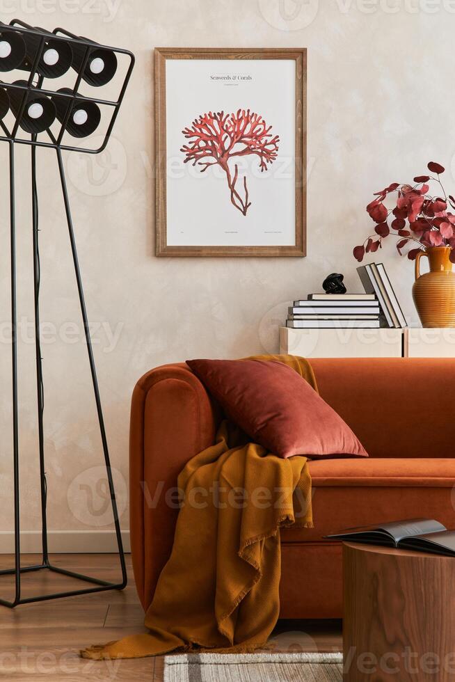 Creative interior composition of living room with designed couch, mock up poster frame, coffee table, black lamp, books and personal accessoriers photo