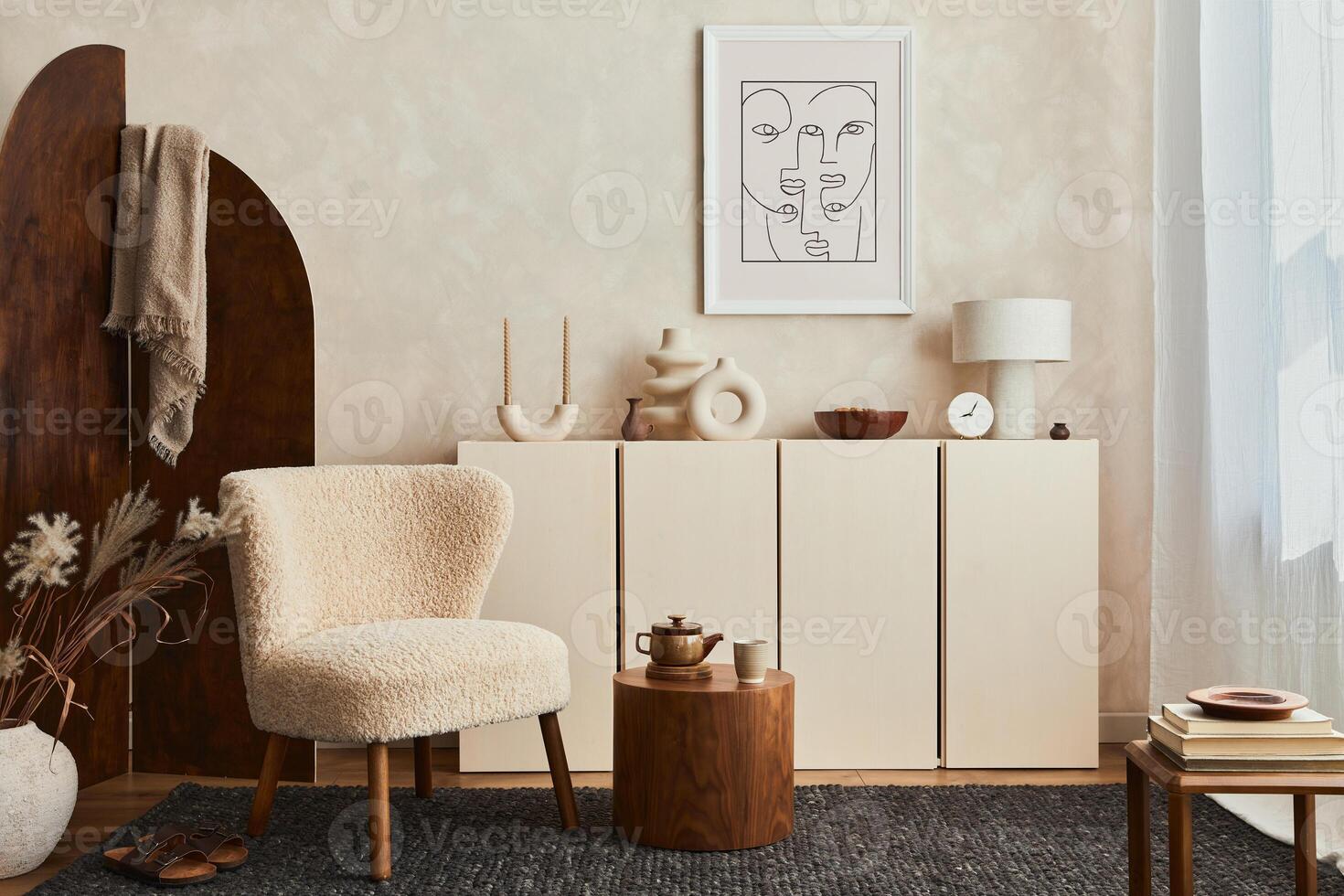 Creative composition of cozy living room interior design with mock up poster frame, fluffy armchair, folding screen, coffee table, commode and personal accessories. Modern style. photo