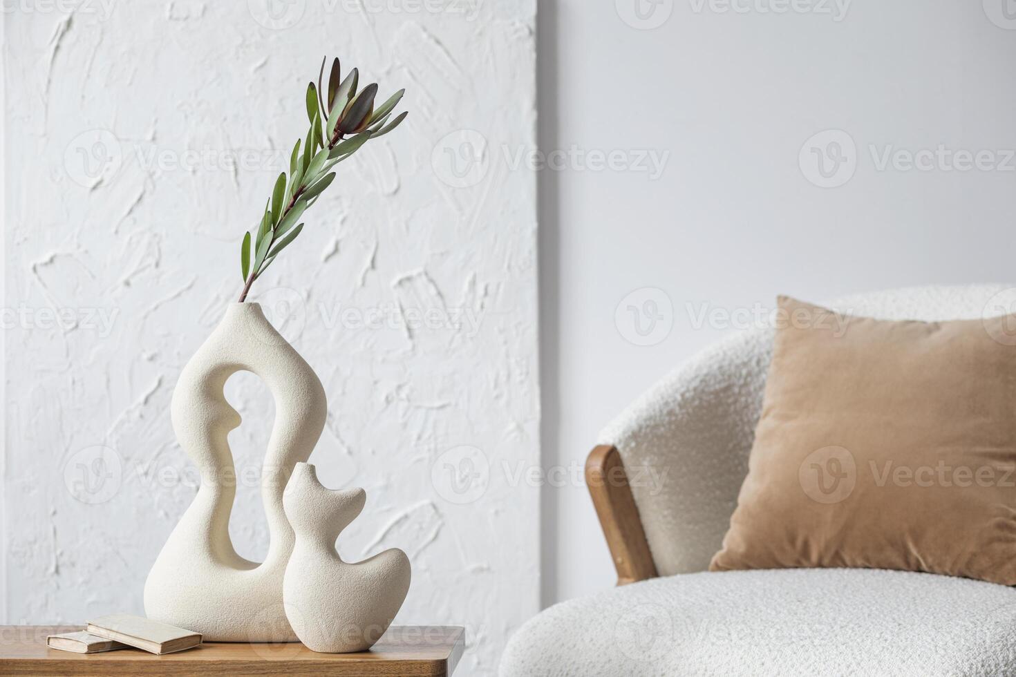Elegant living room interior design with handmade vases, side table, fluffy armchair and personal accessories. Structure painting on the wall. Copy space. Wallpaper. Template. photo