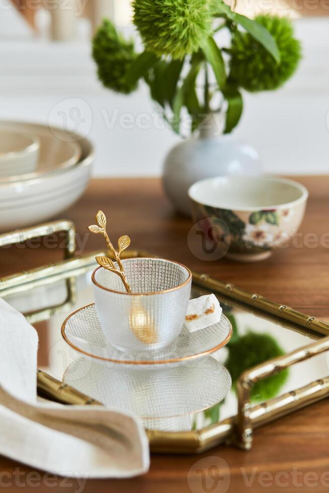 Creative and elegant dining room composition with classy porcelain, golden tray and beautiful personal accessories. Luxury apartments. Beauty in the details. Template. photo
