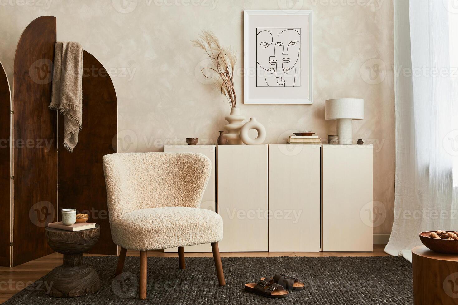 Stylish composition of cozy living room interior design with poster frame, fluffy armchair, folding screen, coffee table, commode and personal accessories. Modern style. Template. photo
