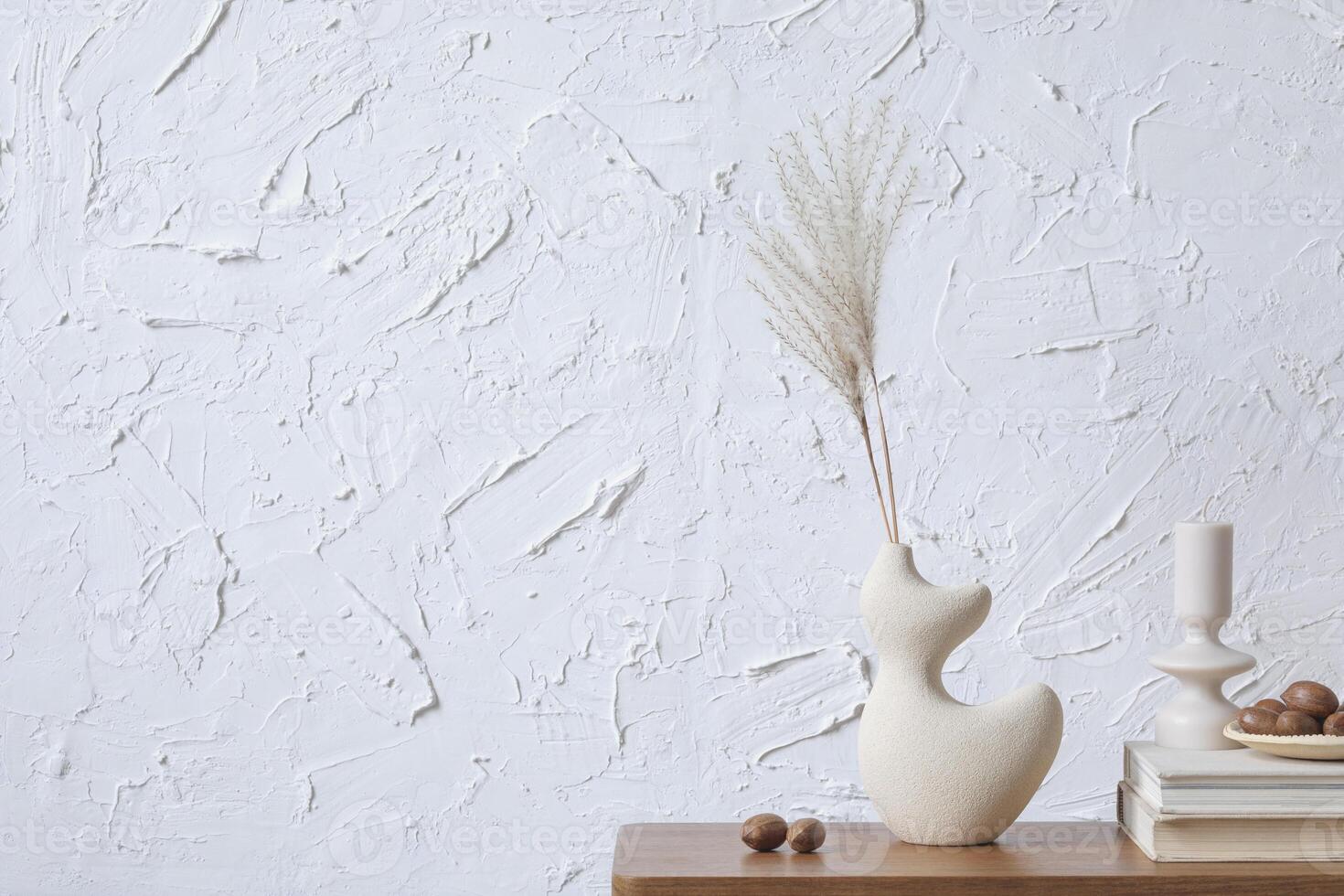Creative minimalistic composition of home interior with handmade clay vase, sidetable and elegant personal accessories. Copy space. Wall paper. Template. photo