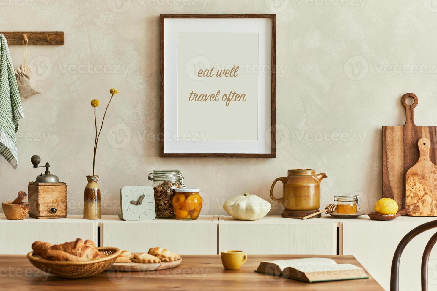 Creative composition of stylish dining room intrerior with poster frames, beige sideboard, family dining table, plants and vintage personal accessories. Copy space. Template. Autumn vibes. photo