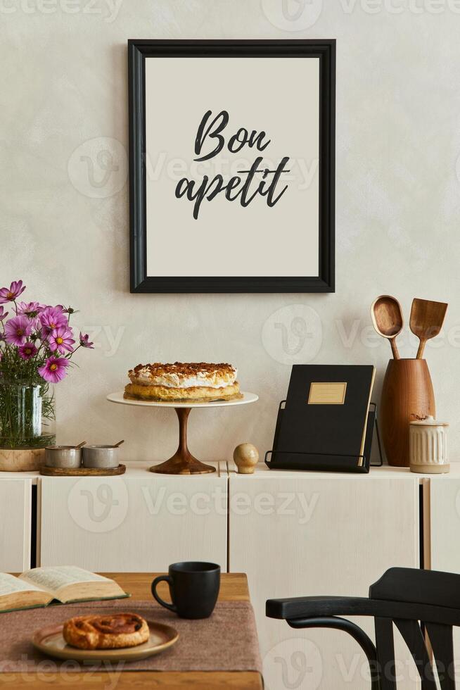 Creative and cozy kitchen interior composition with mock up poster frame, beige commode, plants, chair, family table and elegant accessories. Template. photo
