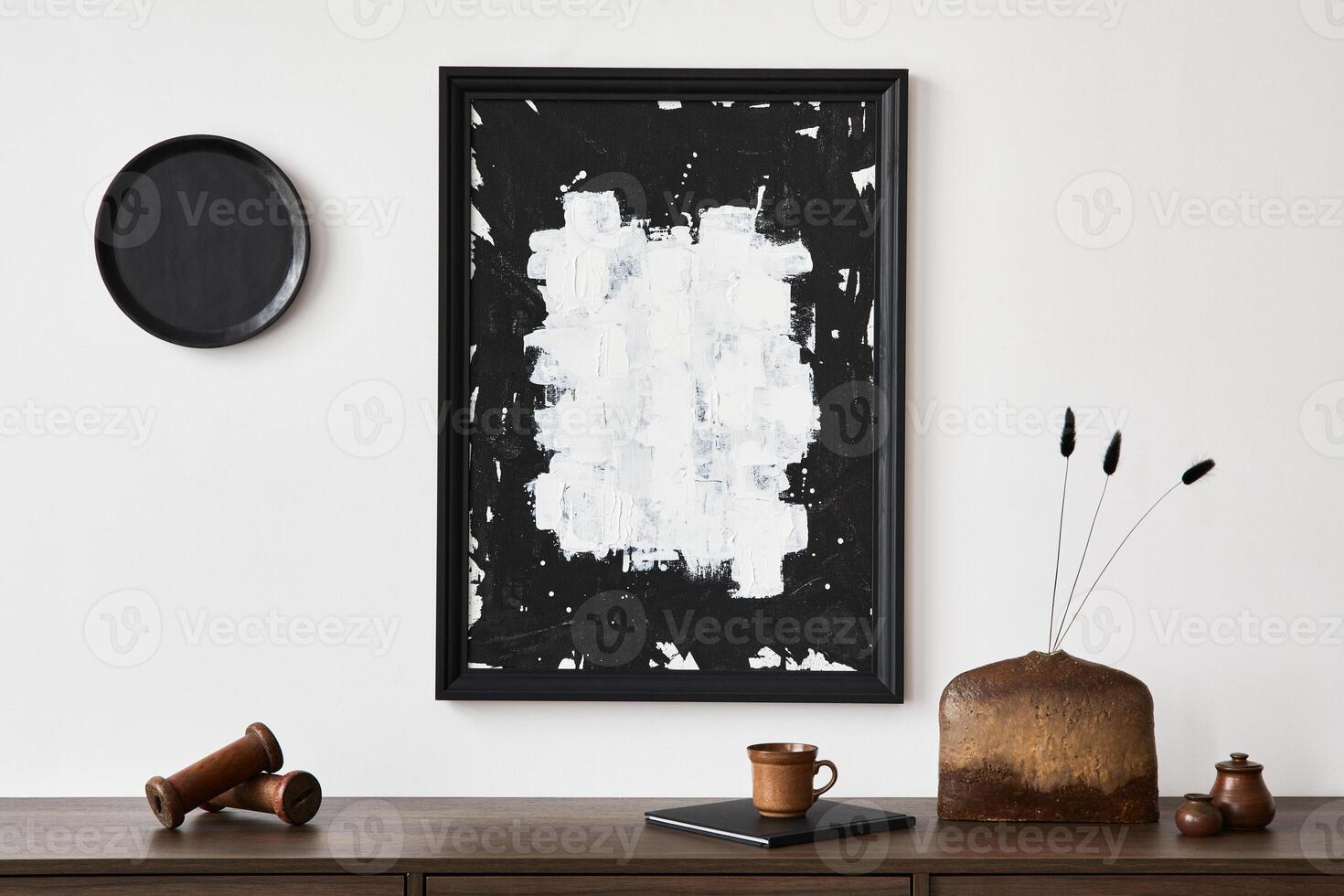 Minimalistic composition of creative living room interior with mock up poster frame and stylish small personal accessories on wooden commode. Copy space Template. photo
