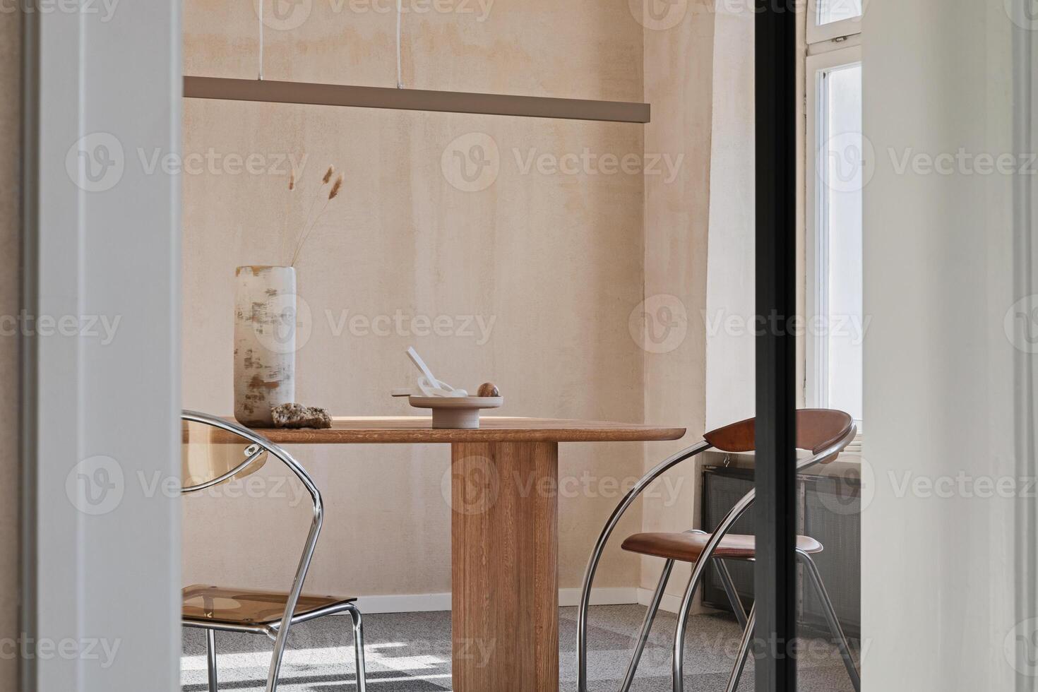 Stylish interior design of spacious dining room with wooden dining table, armchair and beautiful personal accessories. Modern home decor. Structure wall. Rustic minimalitic inspiration. Template. photo