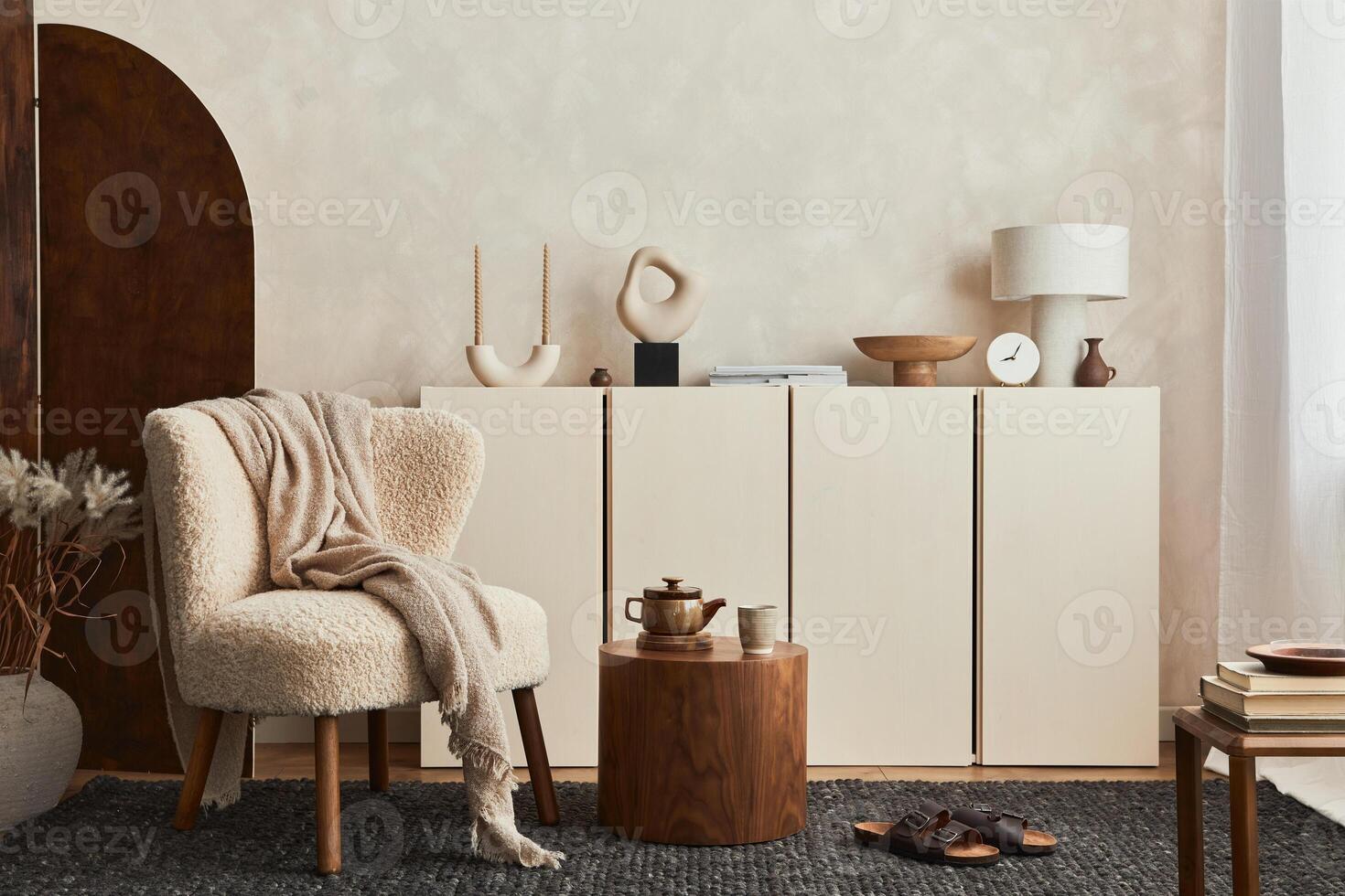 Stylish composition of cozy living room interior design with mock up poster frame, fluffy armchair, folding screen, coffee table, commode and personal accessories. Modern style. . photo