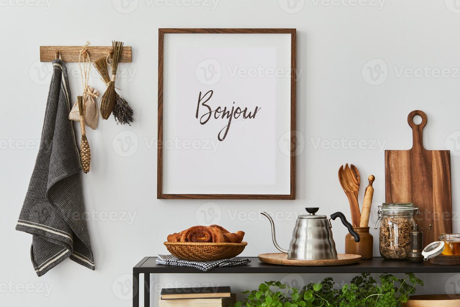 Stylish and cozy kitchen interior composition with mock up poster frame,black console, kitchen textile, teapot, plants and retro inspired accessories. Template. Autumn vibes. photo