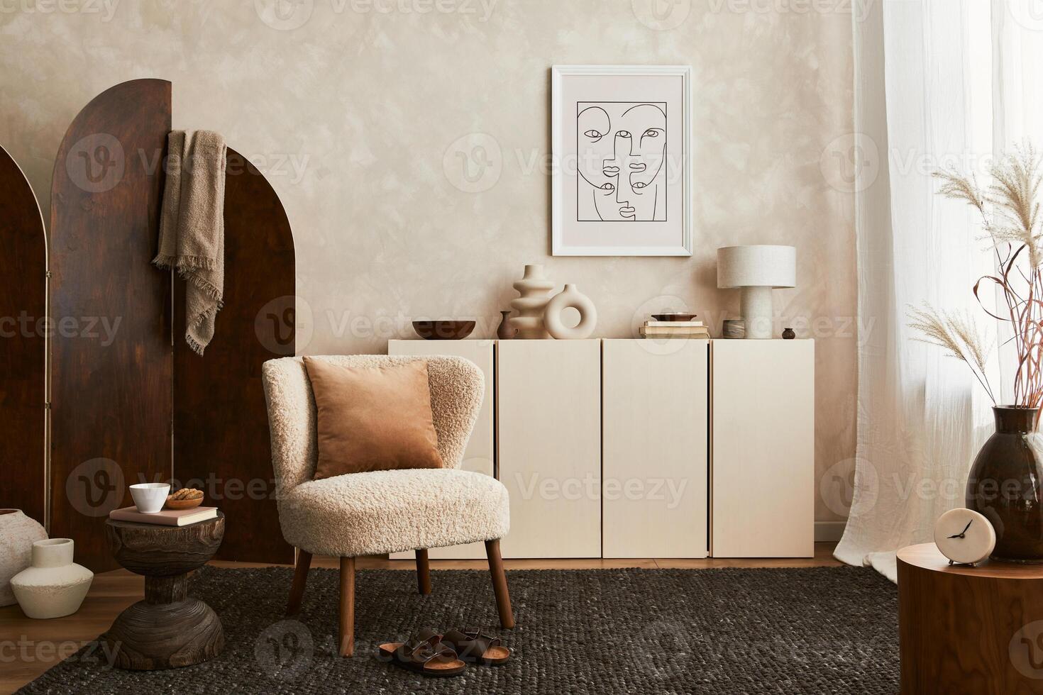Stylish composition of cozy living room interior design with mock up poster frame, fluffy armchair, folding screen, coffee table, commode and personal accessories. Modern style. photo