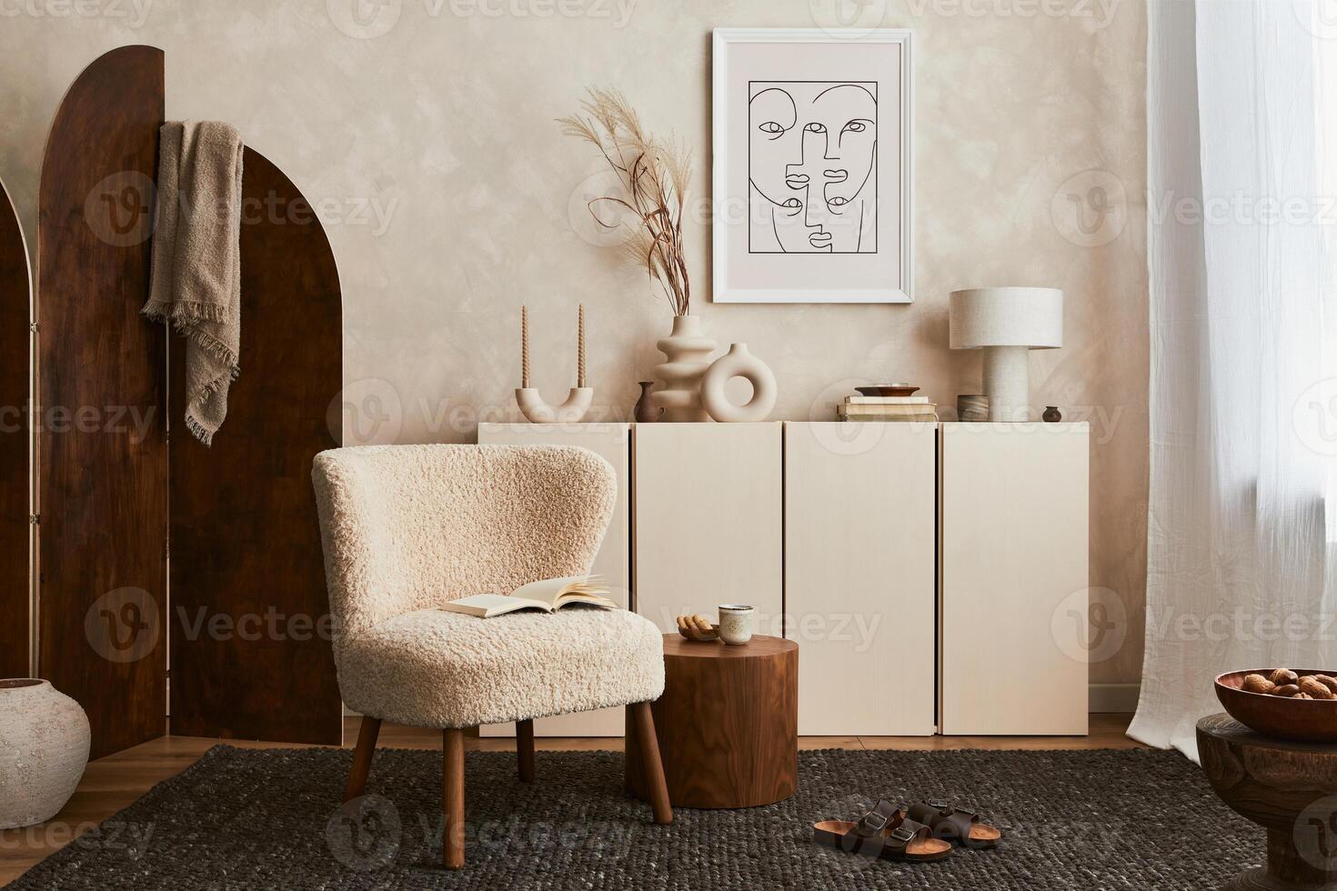 Stylish composition of cozy living room interior design with mock up poster frame, fluffy armchair, folding screen, coffee table, commode and personal accessories. Modern style. photo