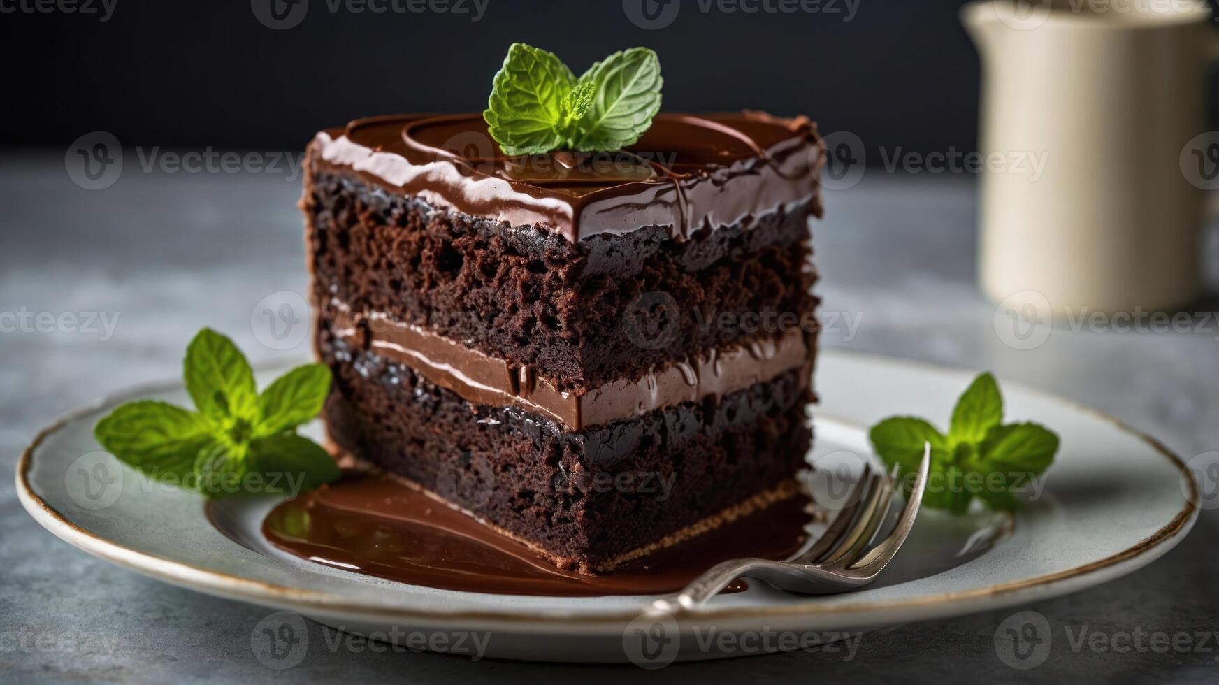 A decadent slice of chocolate cake garnished with mint leaves on a plate. photo