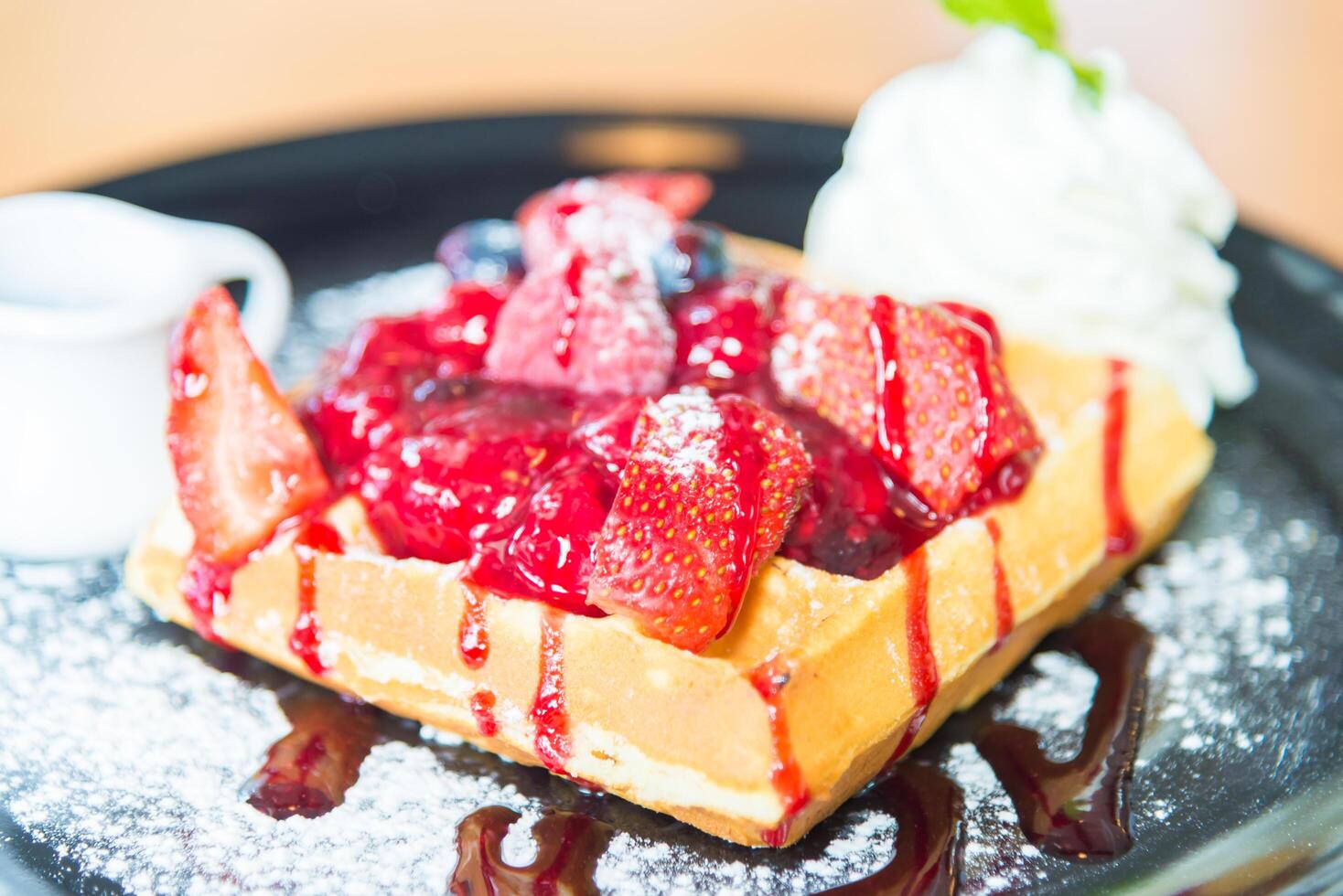 A waffle with berries and syrup on it photo