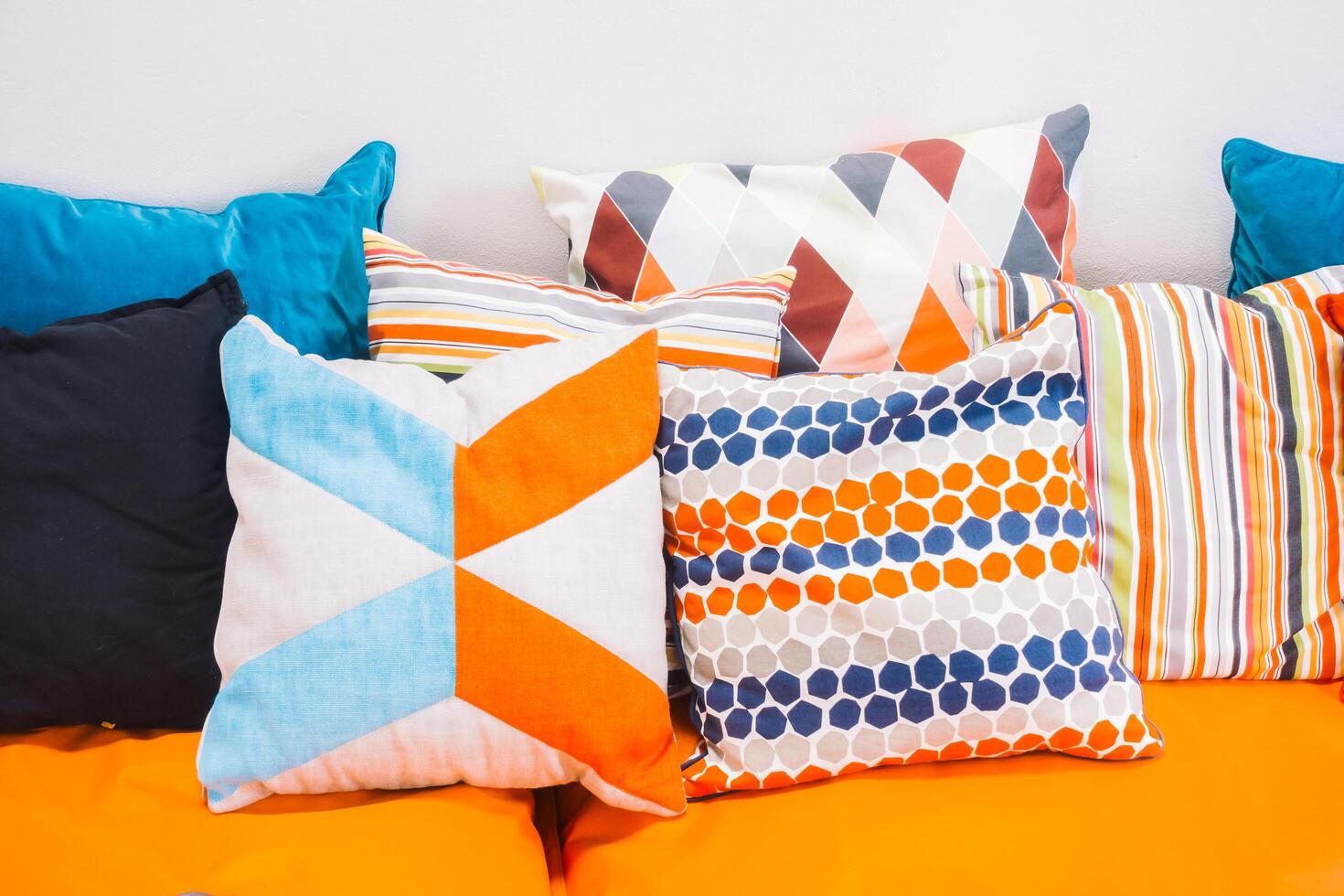 A pile of colorful pillows on a couch photo