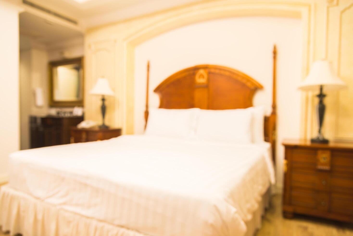 A bed with a white comforter and a wooden headboard photo