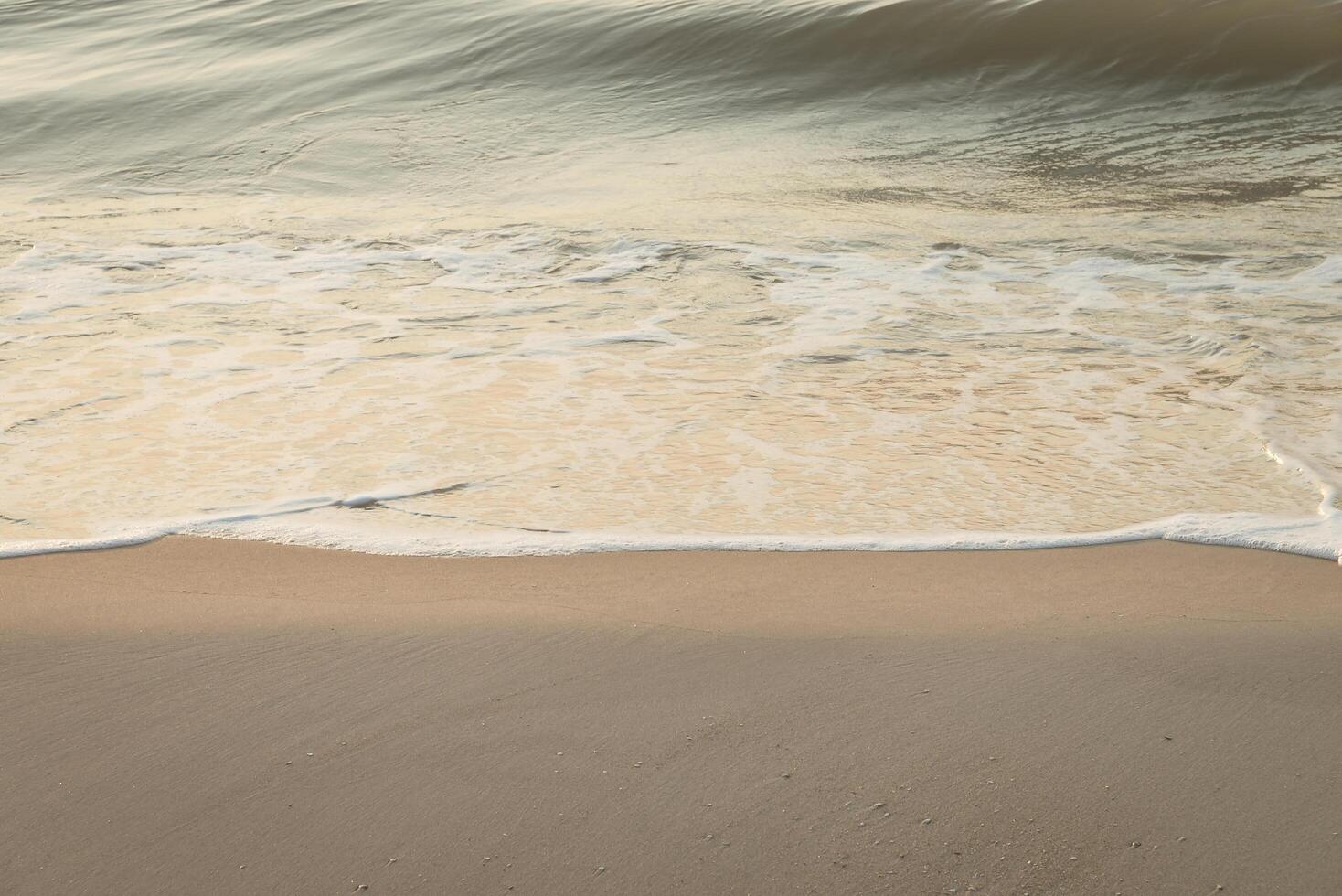 A person walking on the beach with a surfboard photo