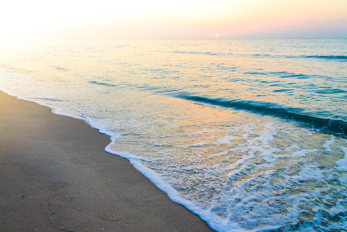 A person sitting on a beach with a surfboard photo