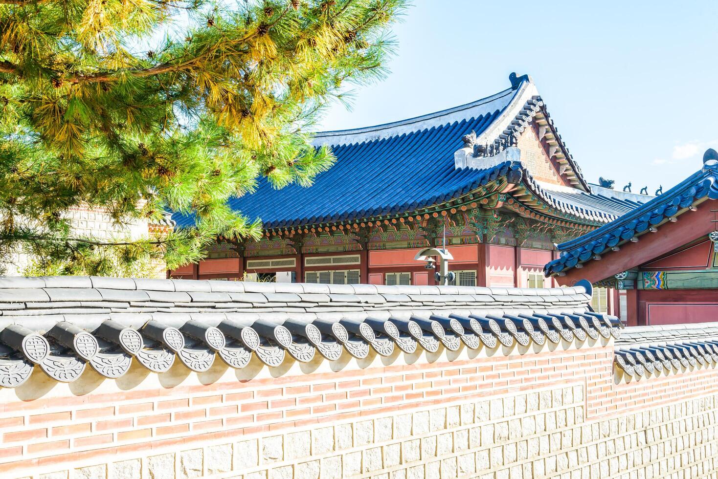 A wall with a roof and a building in the background photo