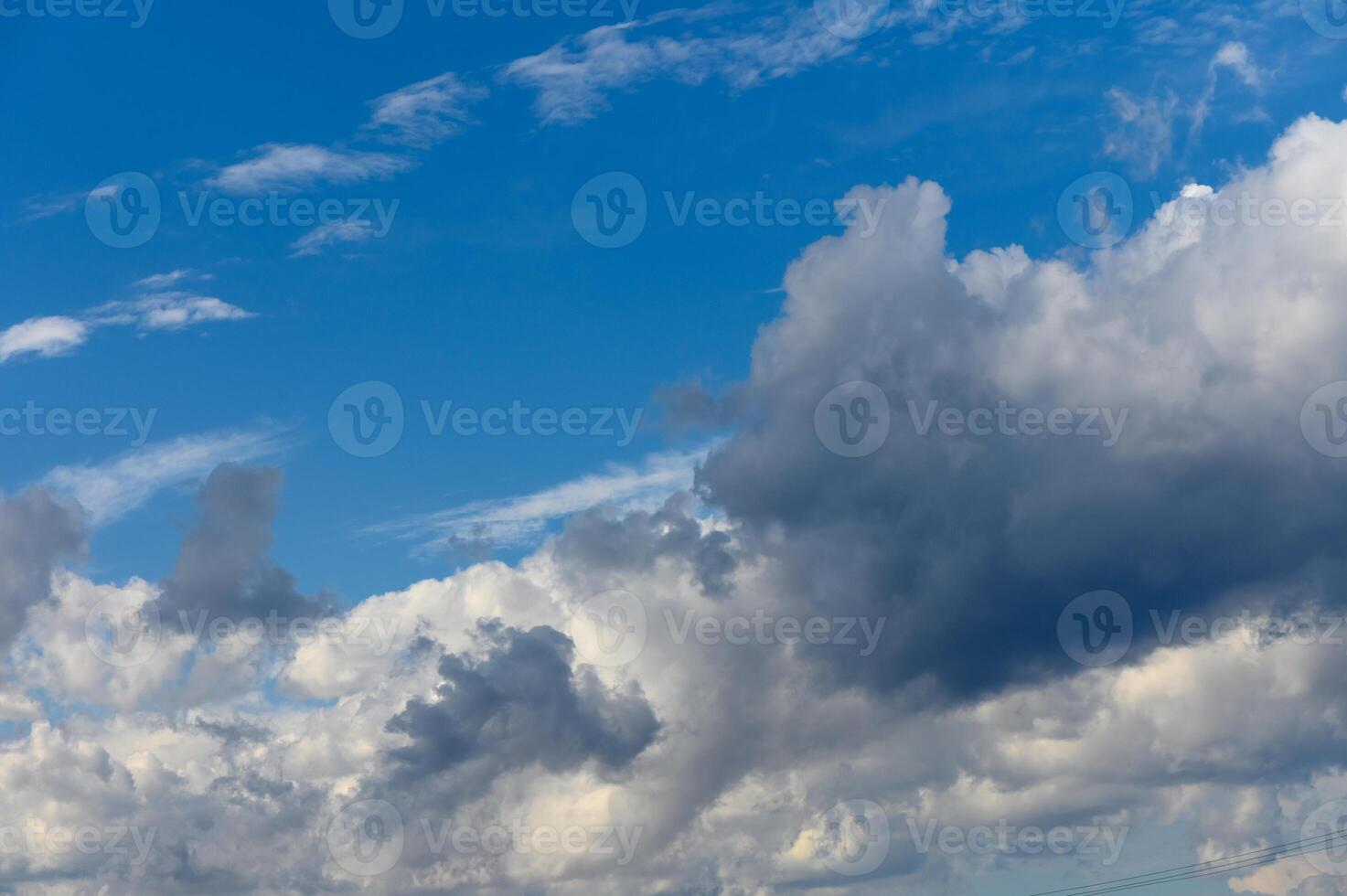 A stunning display of clouds dancing in the vibrant blue sky during a calm afternoon photo