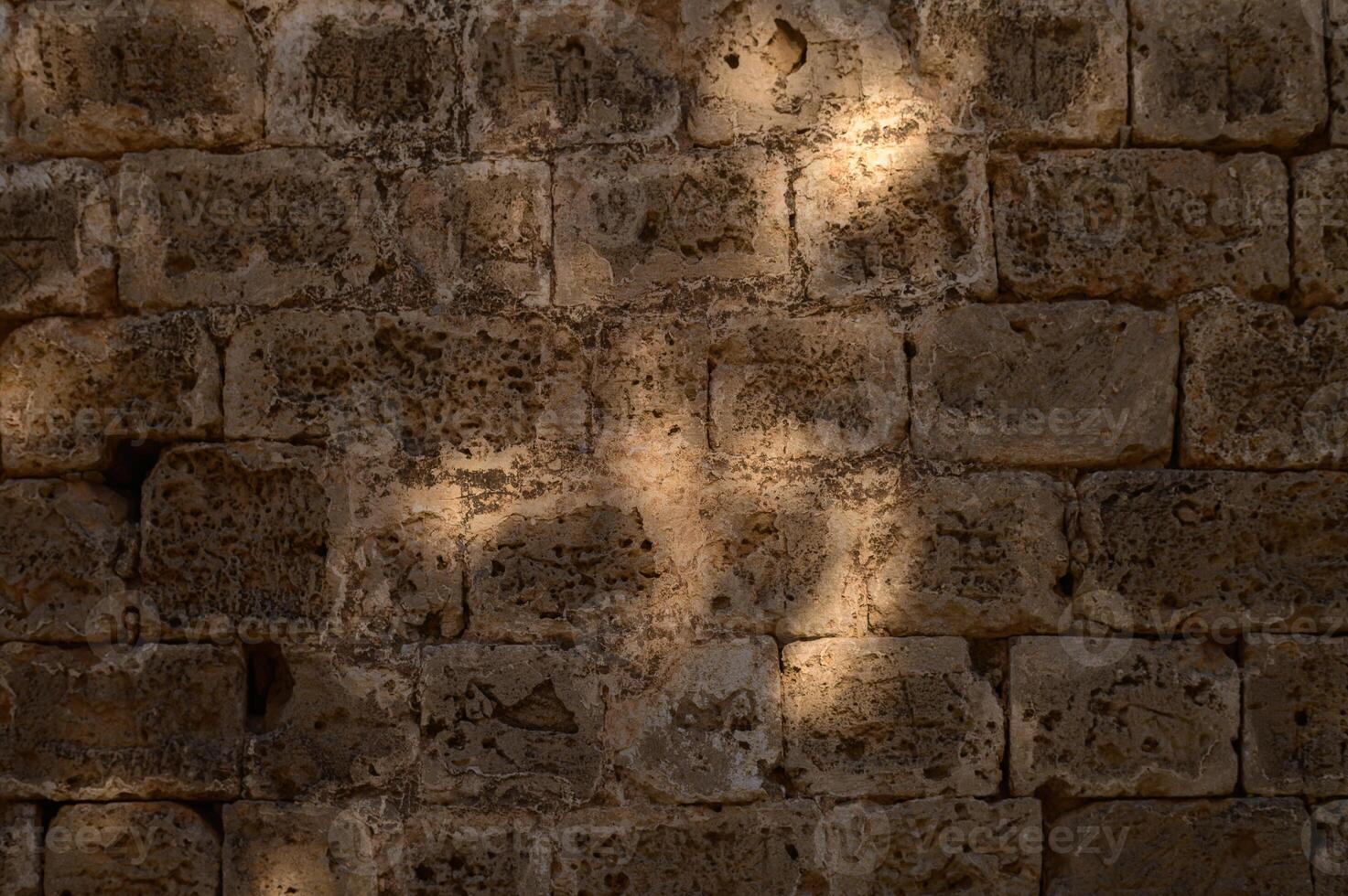 Sunlight dances on an ancient stone wall, creating a beautiful shadow pattern in the quiet afternoon glow photo