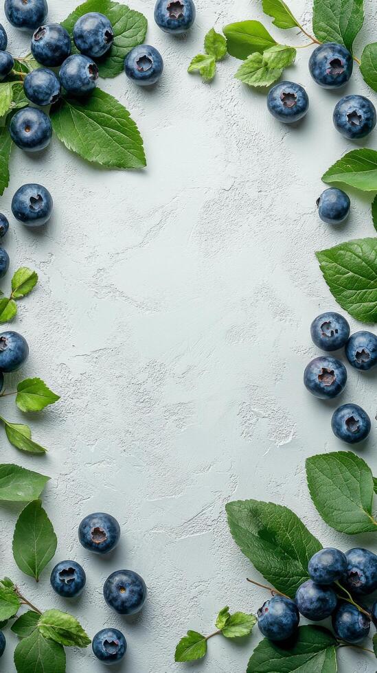 Fresh blueberries surrounded by green leaves arranged on a light background for a natural display photo