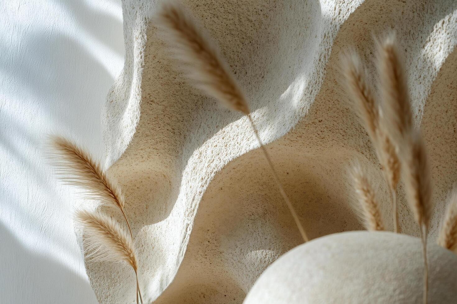 Natural stone sculpture paired with dried grass in a minimalist indoor space during day time photo