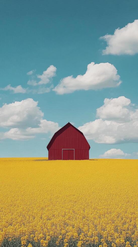 A red barn surrounded by vibrant yellow flowers in a scenic rural landscape with mountains photo