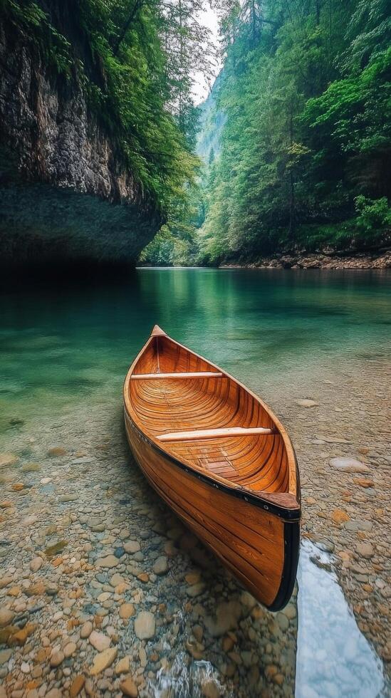 Calm wooden canoe resting on clear water surrounded by lush trees in a tranquil setting photo