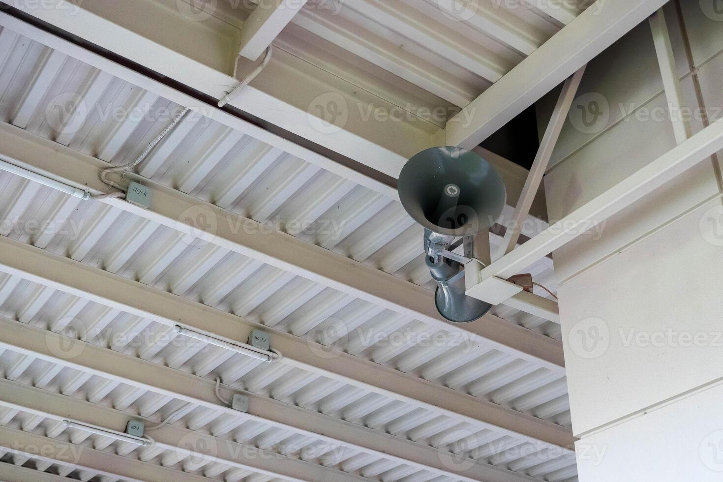 Public address system hanging from metal ceiling structure photo