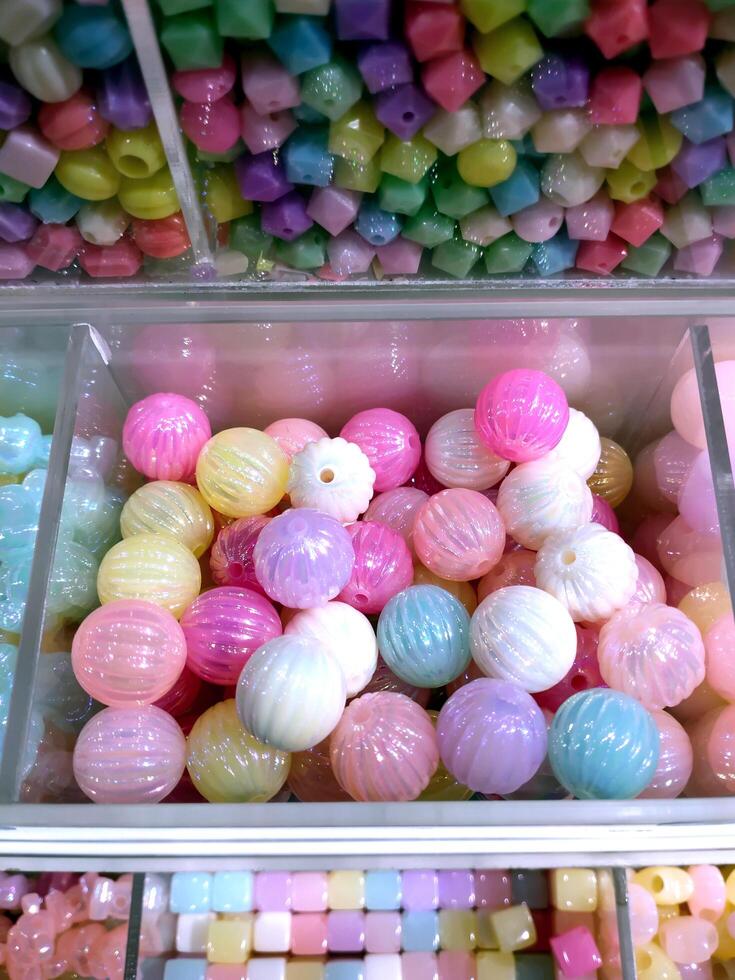 Colorful and vibrant display of bead balls fills a glass case in a store. Accessories things. Do it yourself creativity. photo