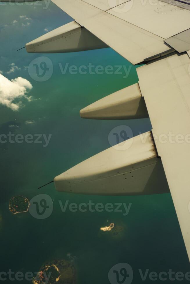 Photos View of airplane wing turbines over small islands. In the photo from inside the plane. Holiday events
