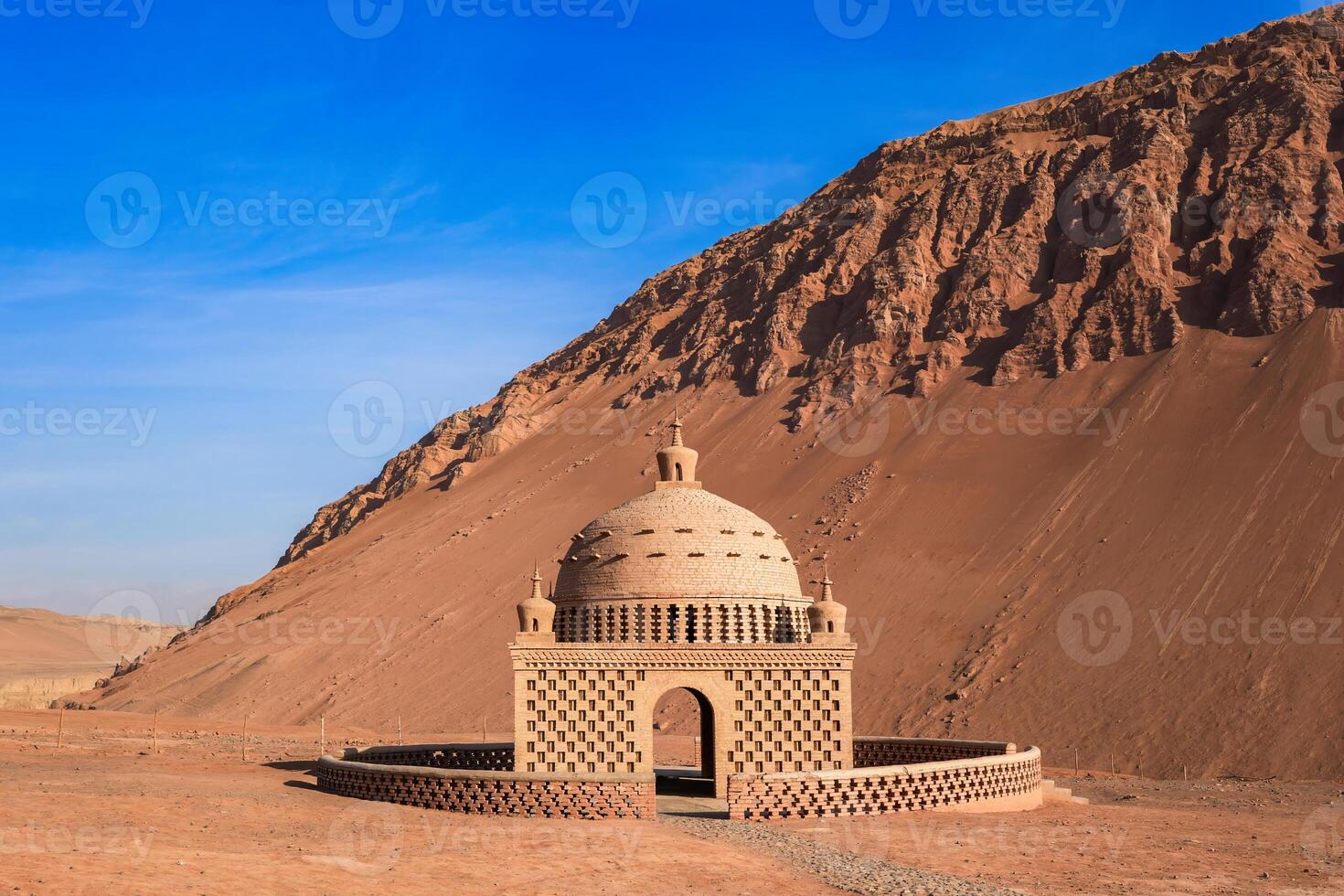 The mud building in uyghur style wirh moutain on background. photo