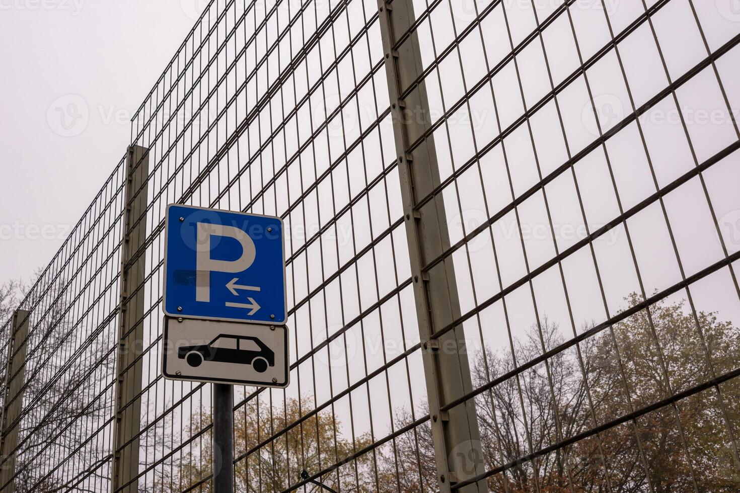 Parking sign indicating available parking spaces behind metal fence photo