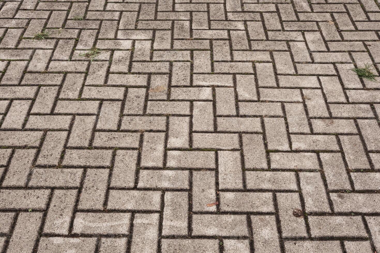 Herringbone pattern brick paving forming textured ground surface photo