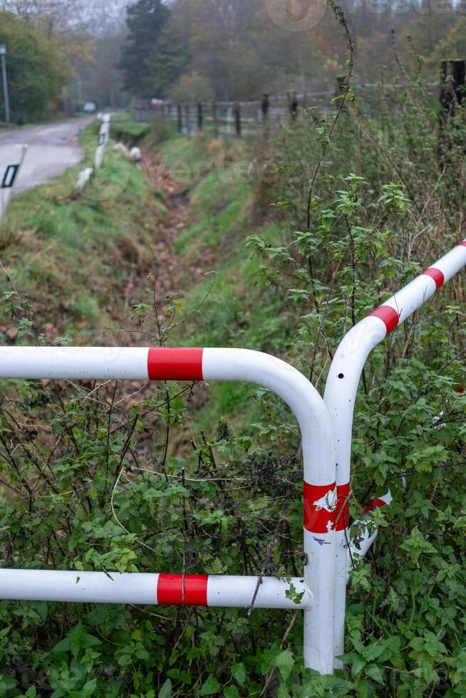 White metal barrier protecting small ditch along country road photo