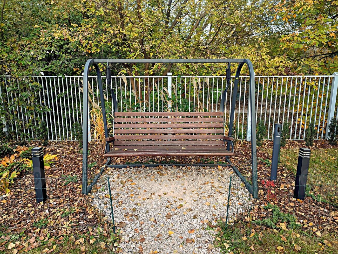 An empty swing bench in the autumn park photo
