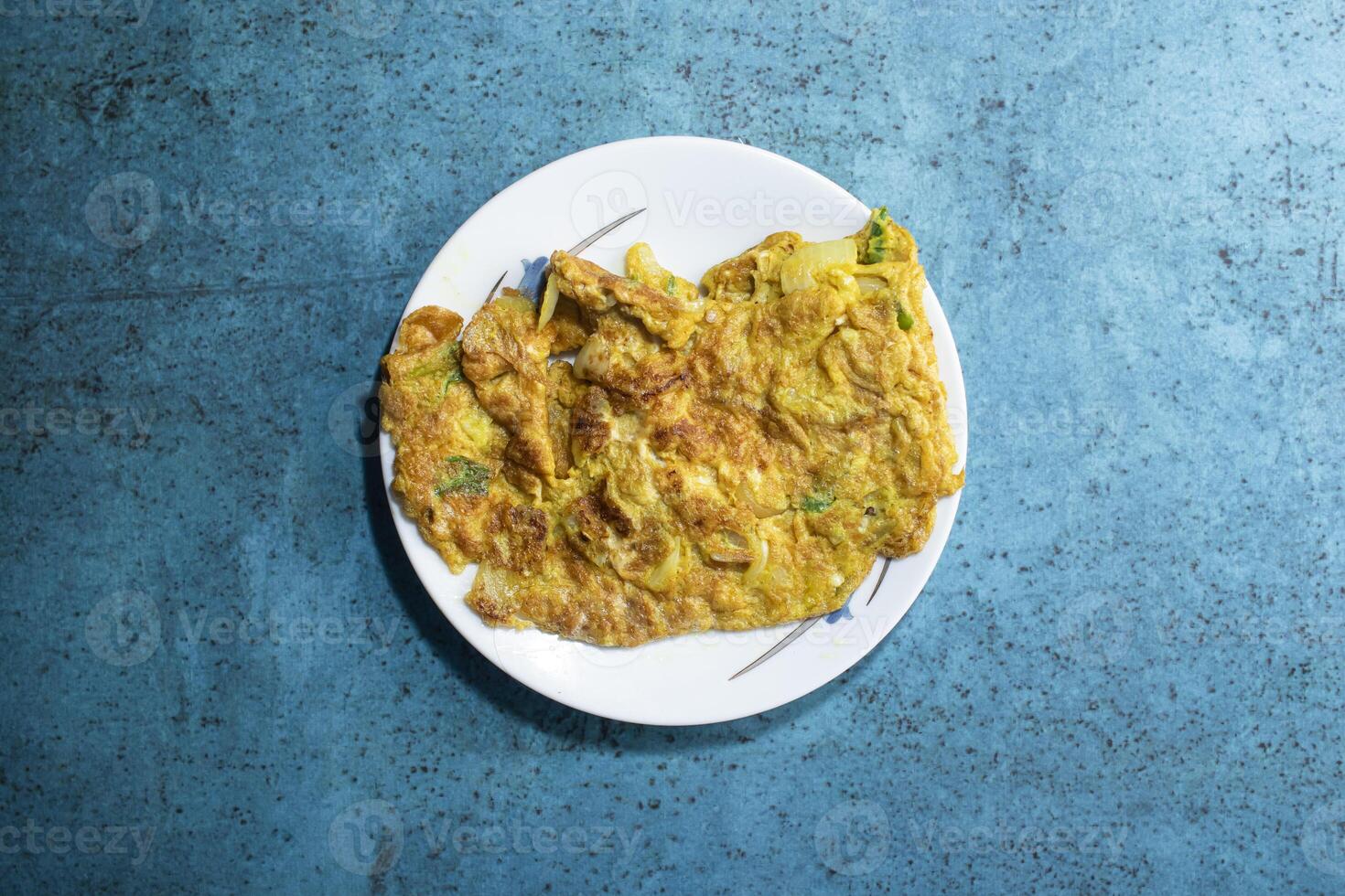Dim bhaji or egg omelette served in plate isolated on sky background top view of bangladeshi food photo