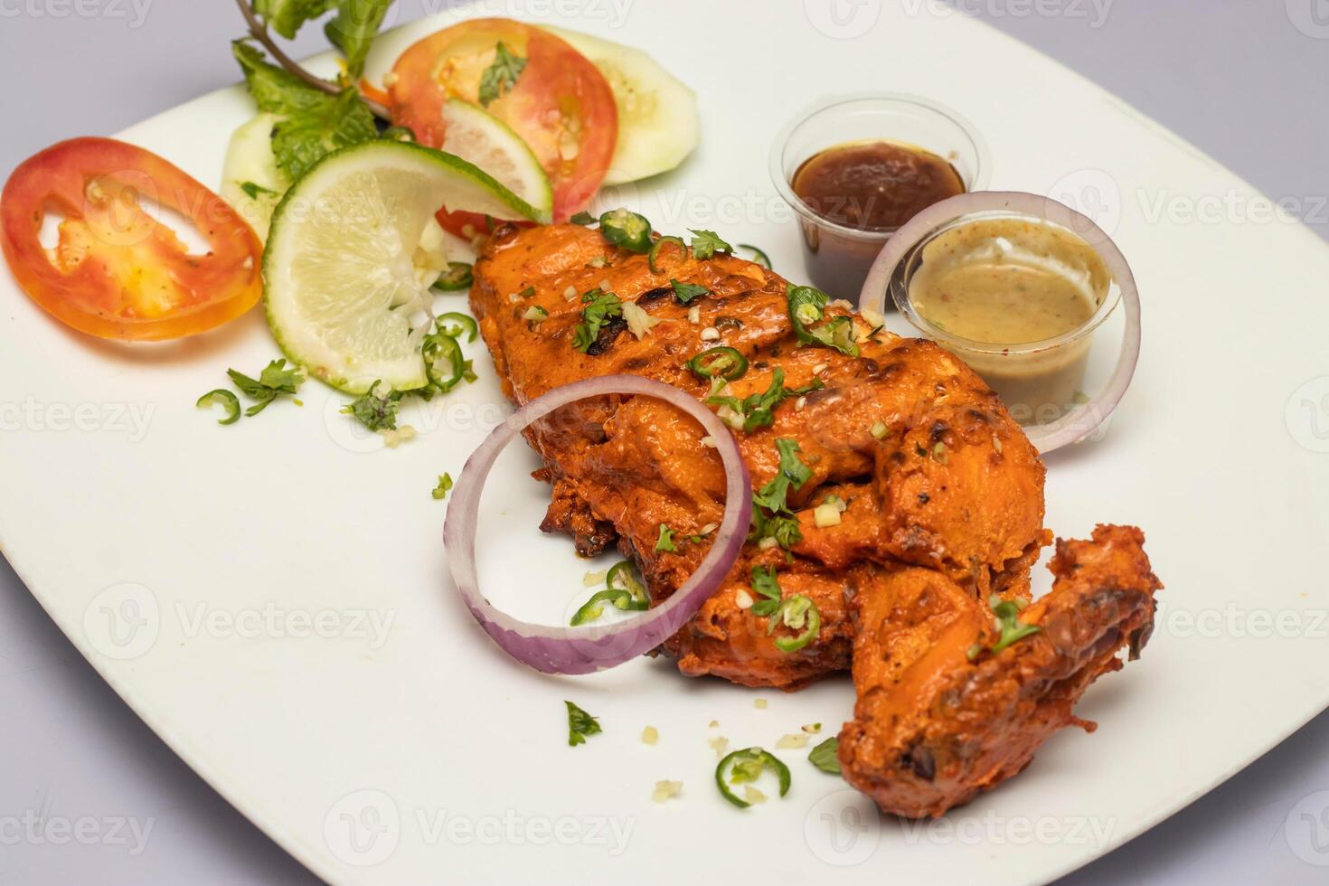 Tandoori Chicken Breast with salad and chutney sauce served in plate isolated on grey background side view of bangladesh, indian and pakistani food photo