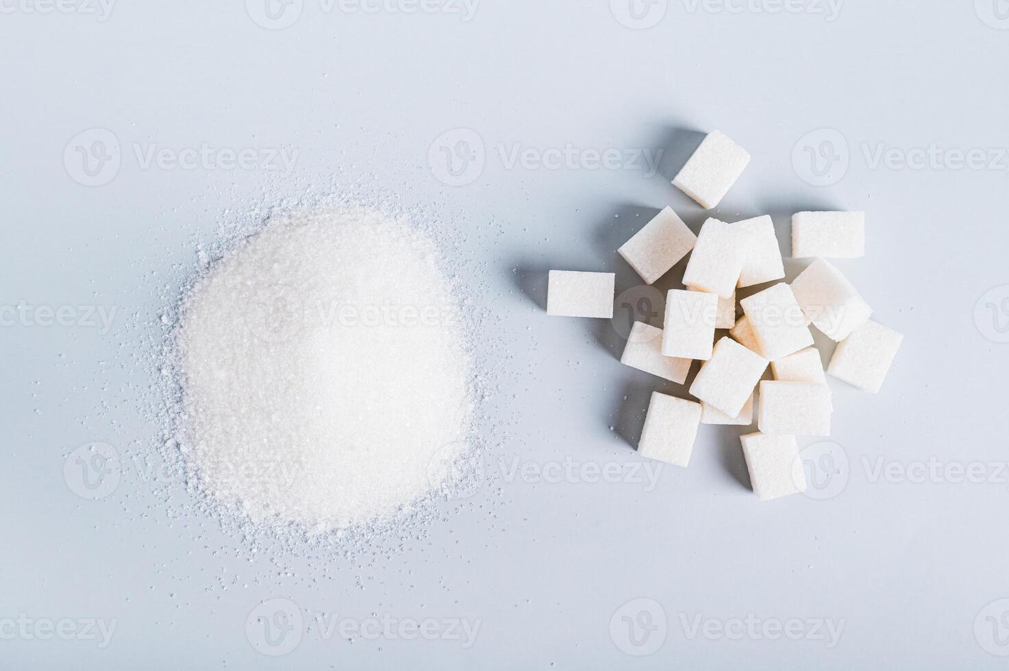 Alternative between lump sugar and granulated sugar on a blue background top view photo