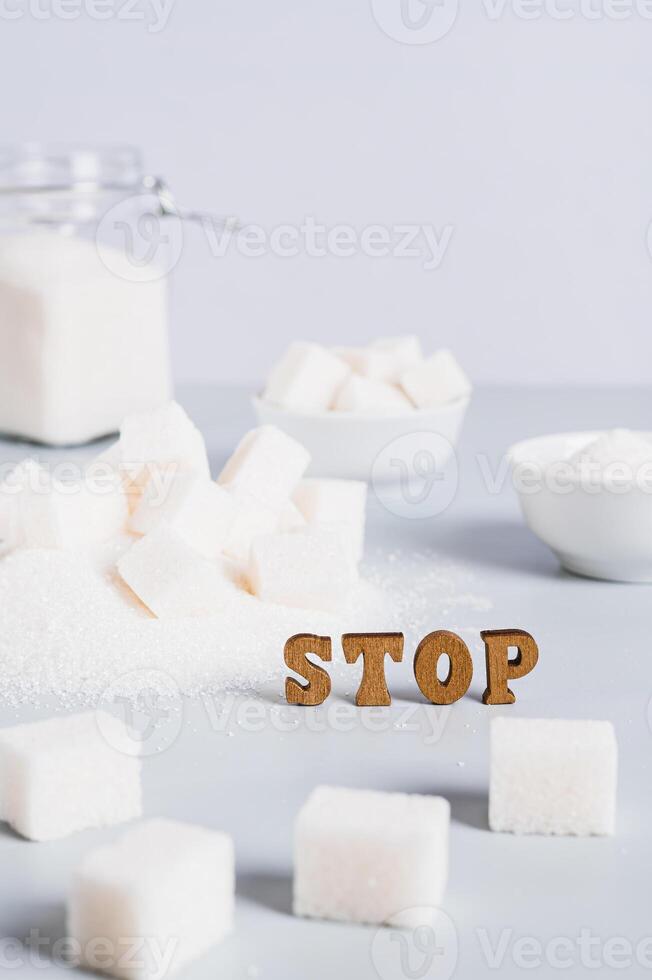 Concept of limited sugar consumption, text and sugar on the table vertical view photo