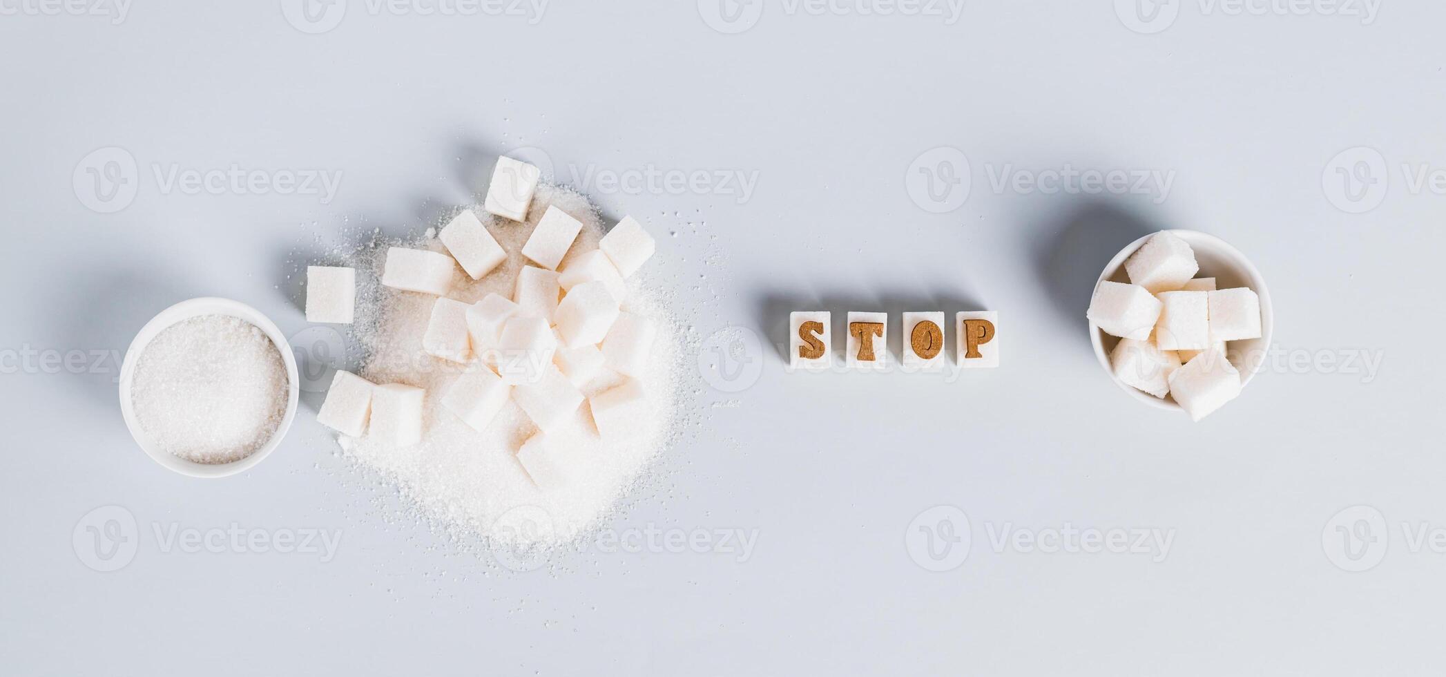 The word stop on pieces of refined sugar as a symbol of refusal from sugar top view web banner photo
