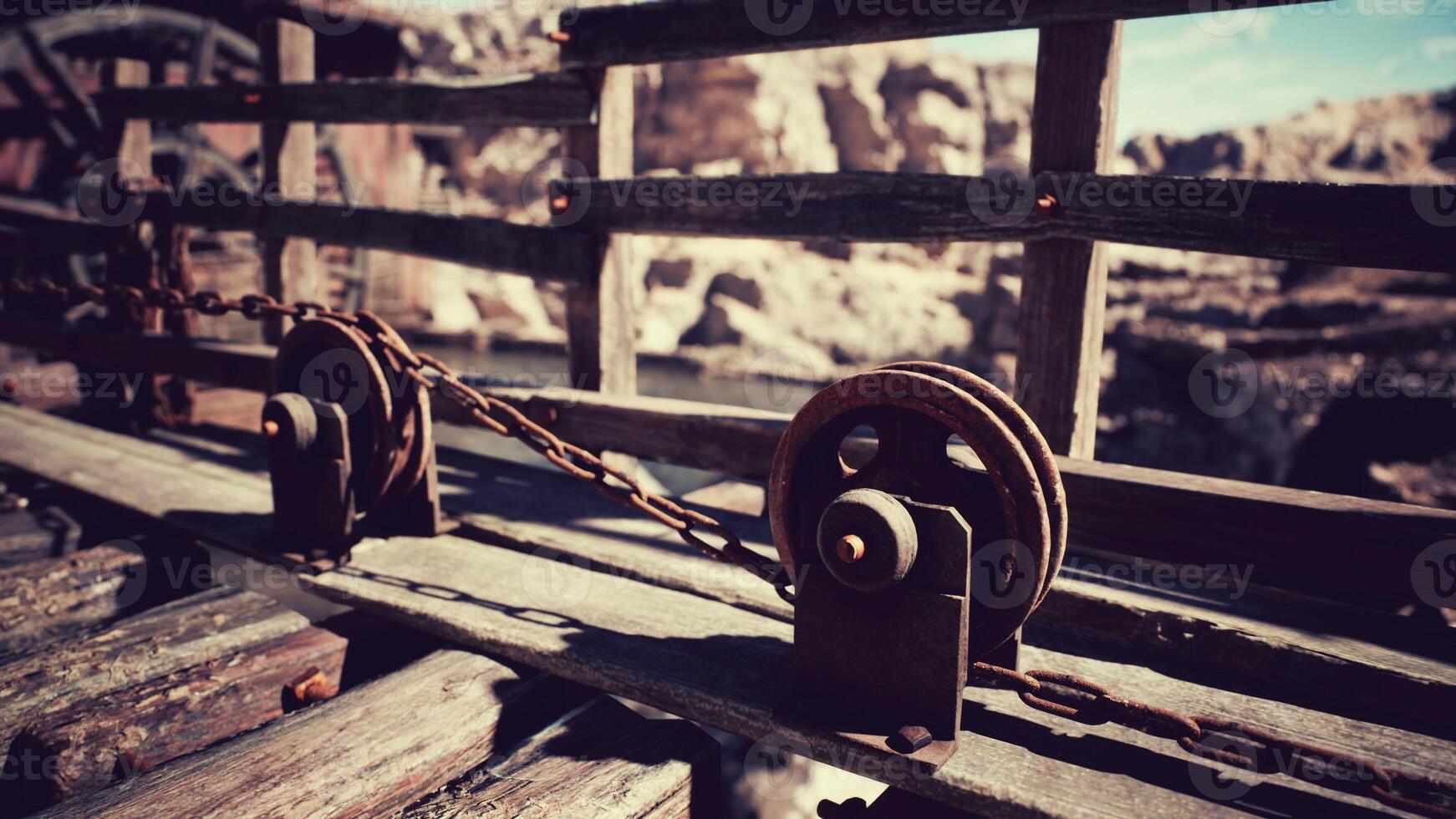 Rustic wooden pulley system on a weathered bridge in a serene landscape photo