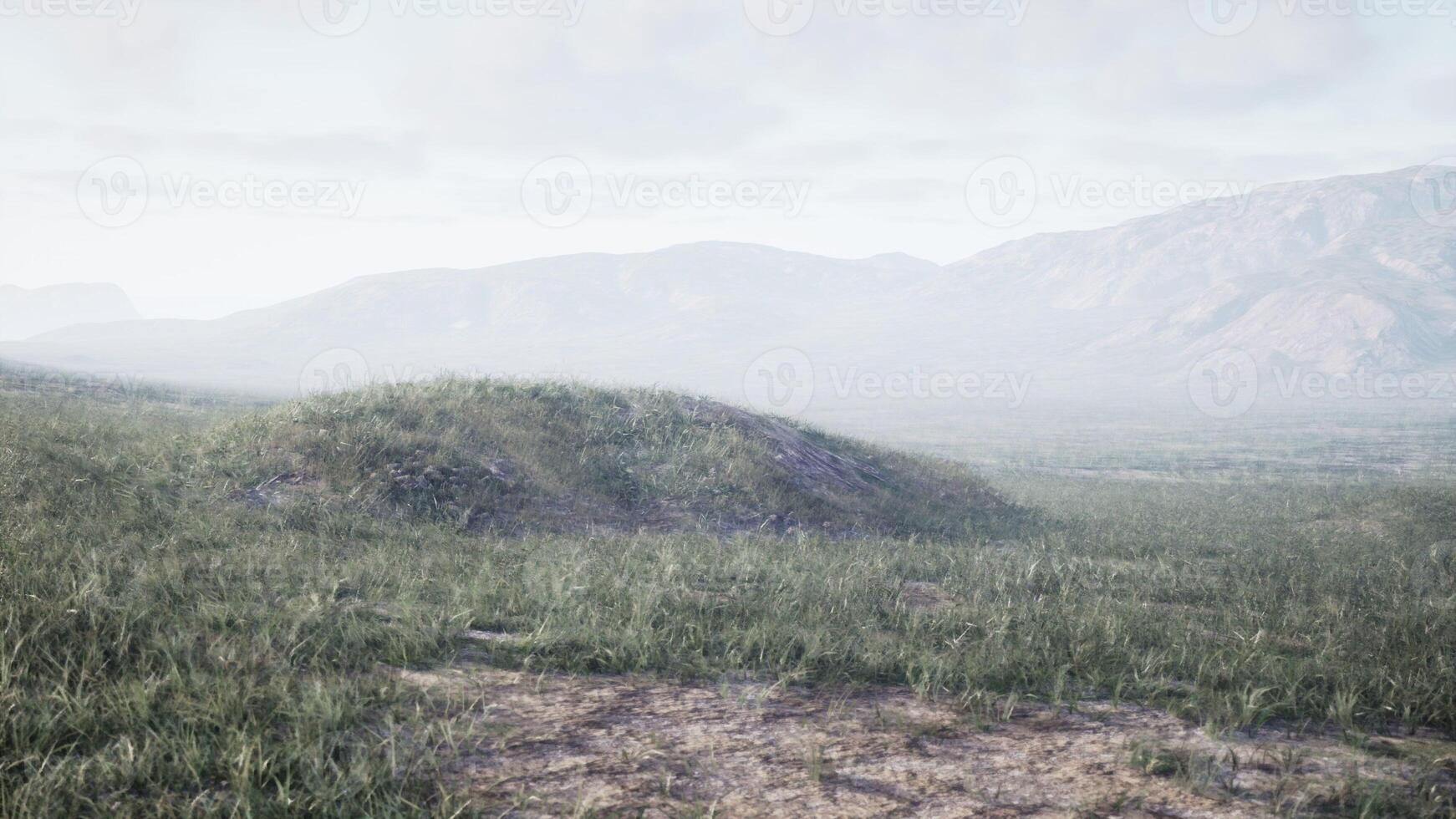 A serene landscape with rolling hills and majestic mountains in the distance photo