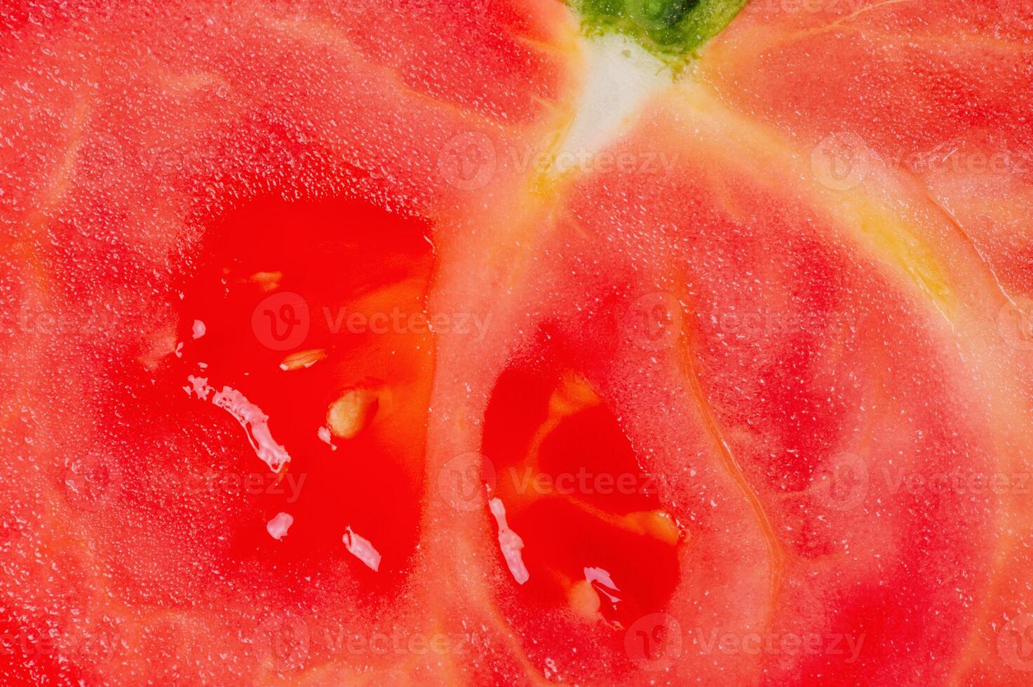 Red ripe cut tomato as a macro photo background.