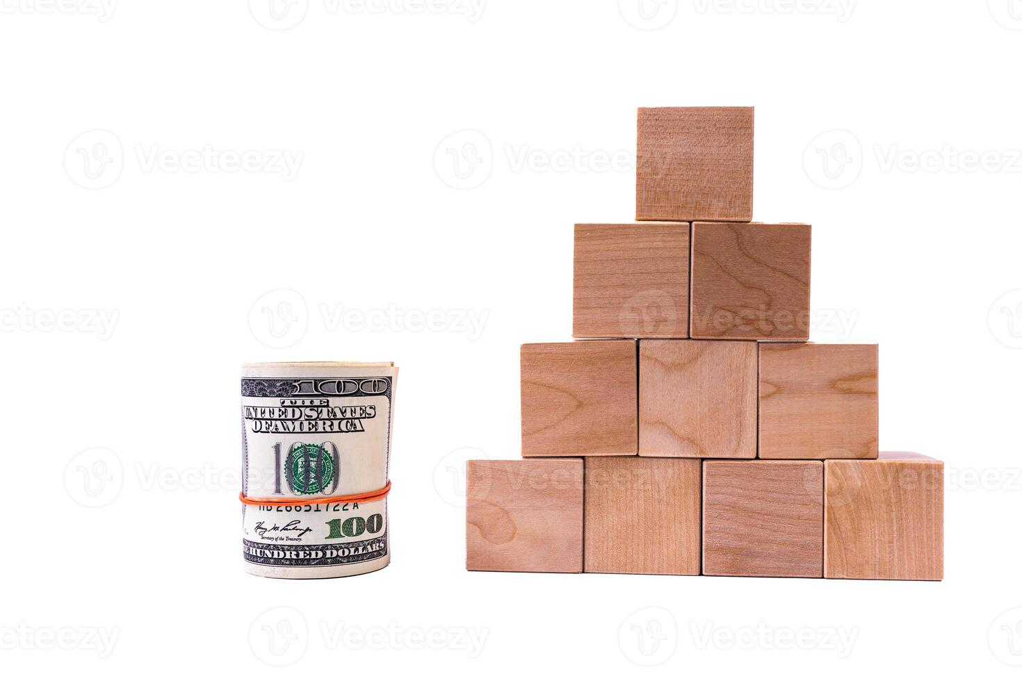 Wooden cubes in the form of a pyramid with a roll of dollars. Financial pyramid. copy space. photo