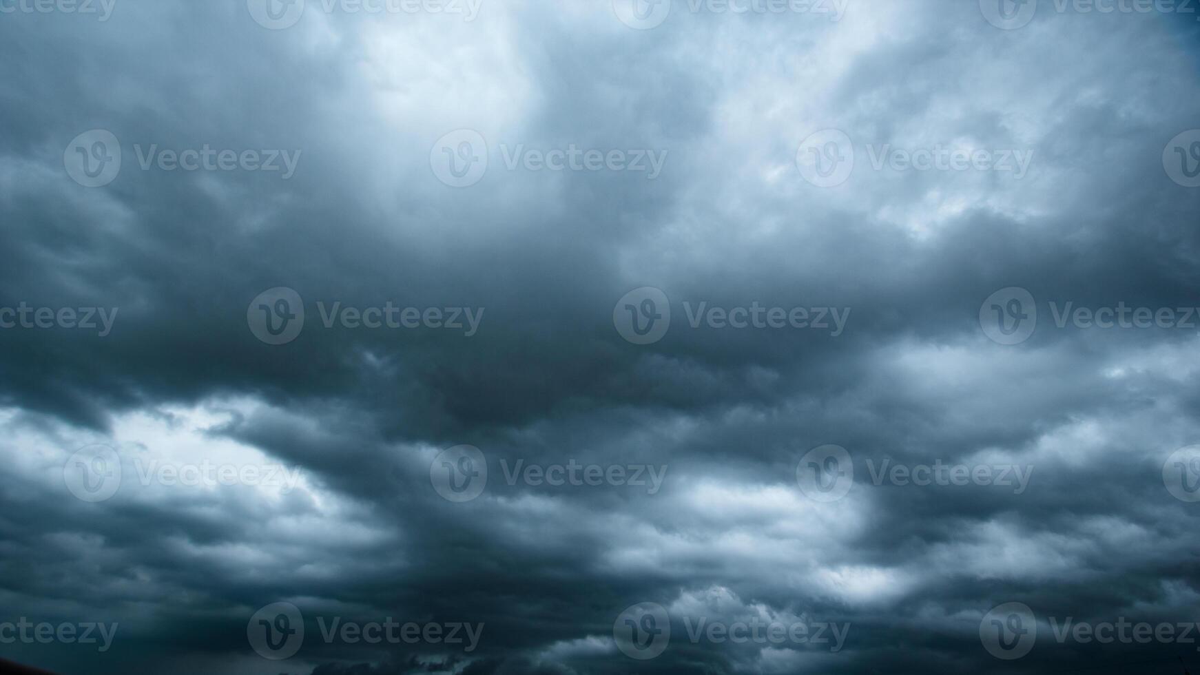 The dark sky with heavy clouds converging and a violent storm before the rain.Bad or moody weather sky and environment. carbon dioxide emissions, greenhouse effect, global warming, climate change. photo