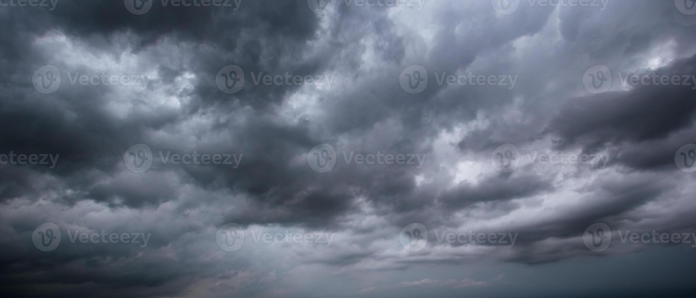 The dark sky with heavy clouds converging and a violent storm before the rain.Bad or moody weather sky and environment. carbon dioxide emissions, greenhouse effect, global warming, climate change. photo
