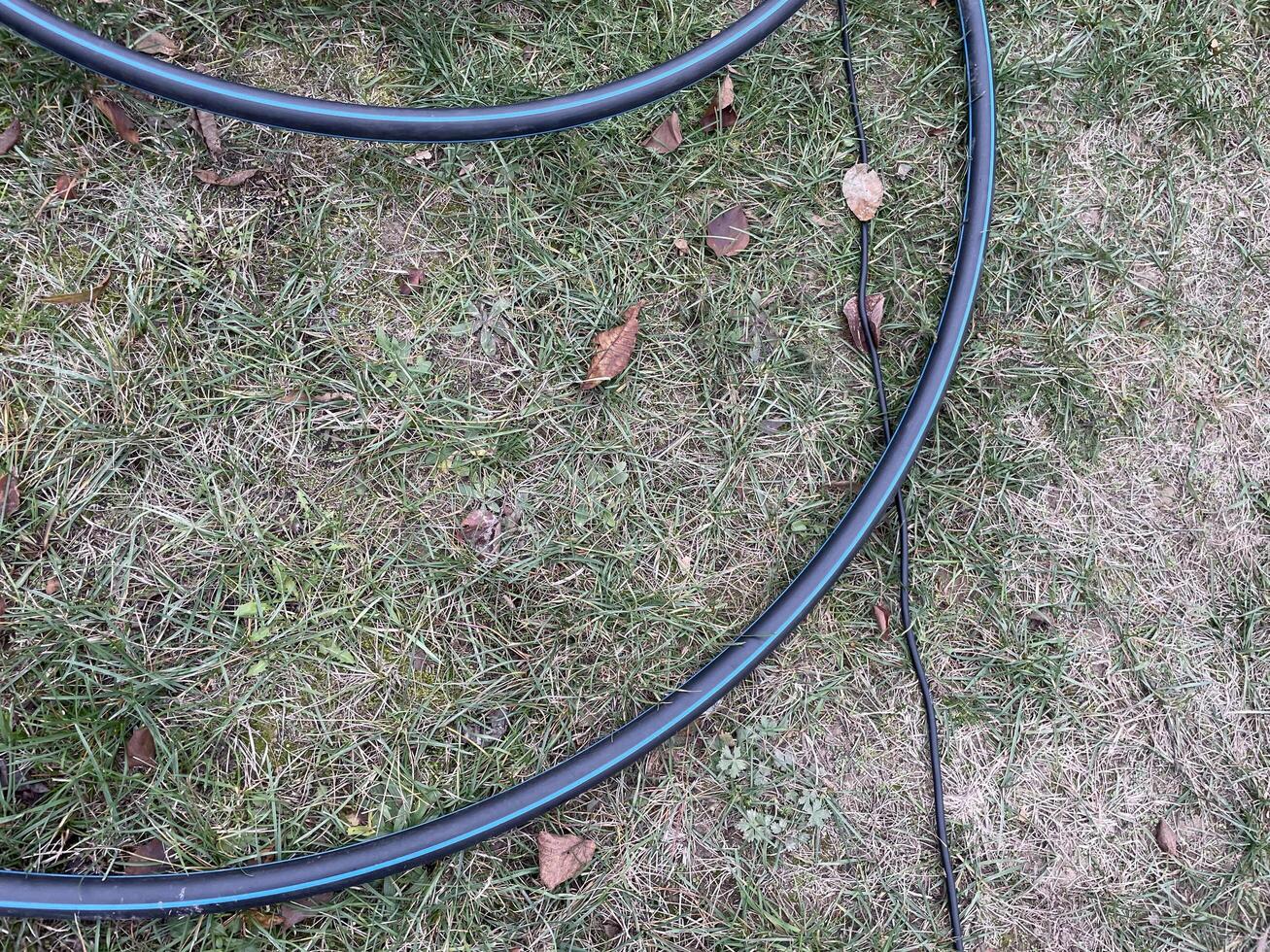 Garden hose laid out in vegetable garden rows photo