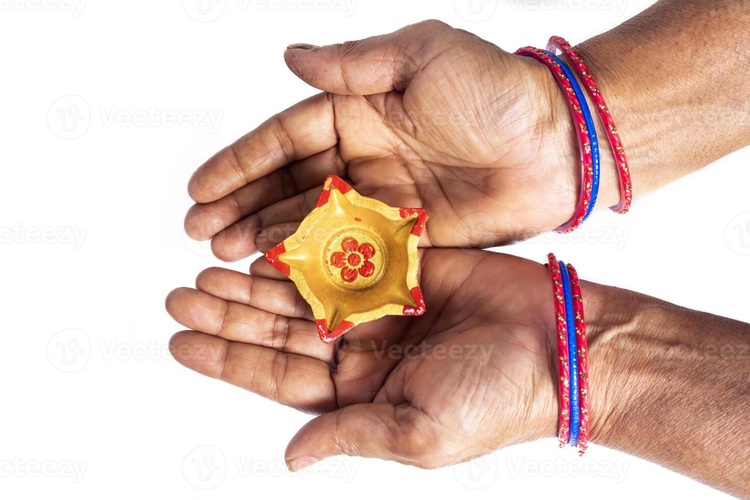 Hands with Colorful Bangles Holding Diwali Oil Lamps for Festive Decor photo