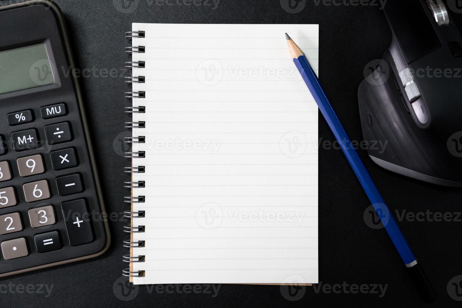 Top view of notebook. Blank paper notepad on office desk table with keyboard and other supplies. Blank notebook page for input the text. copy space, flat lay. photo