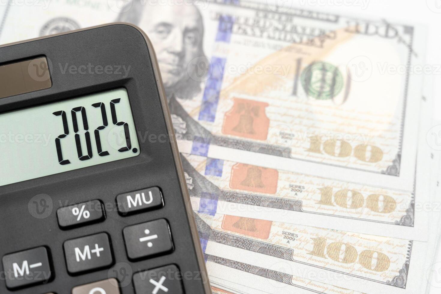 US Dollar banknotes, calculator and forecast for finances in 2025. Money, Budget, tax, investment, financial, savings and New Year Resolution concepts. calculator with 2025 numbers. photo